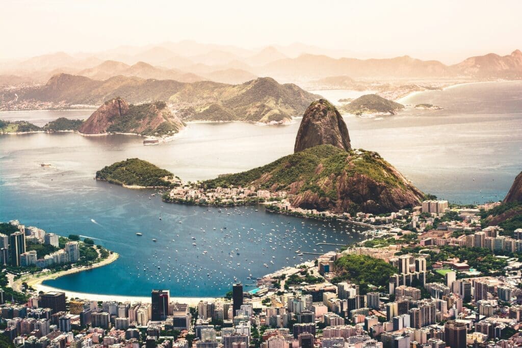 Sugarloaf Mountain Aerial view of Sugarloaf Mountain and Guanabara Bay in Rio de Janeiro, Brazil, with boats in the water and city buildings in the foreground