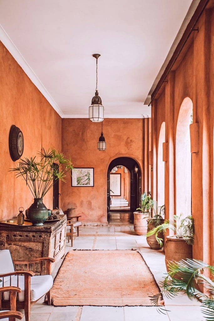 Photo by maria orlova on unsplash Rustic terracotta corridor with arched windows, potted plants, and Moroccan-style decor