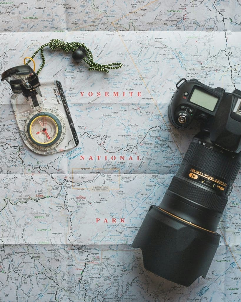 Photo by Cam Dicecca on Unsplash Camera with map and compass on Yosemite National Park map for adventure planning concept