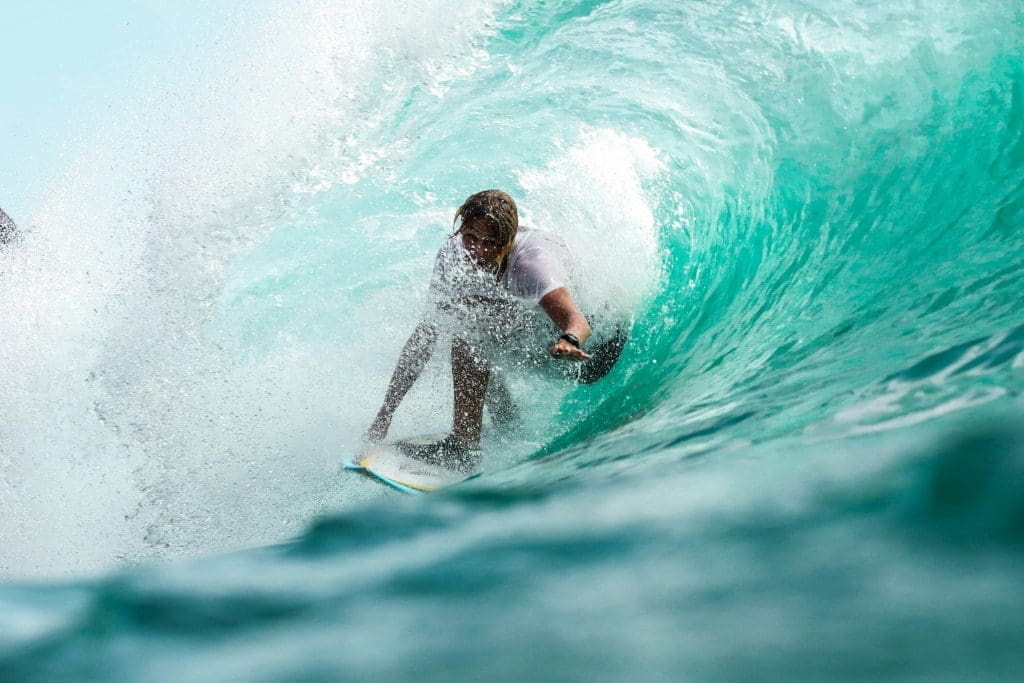 Photo by Jeremy Bishop on Unsplash Surfer riding inside turquoise wave barrel with spray crashing around