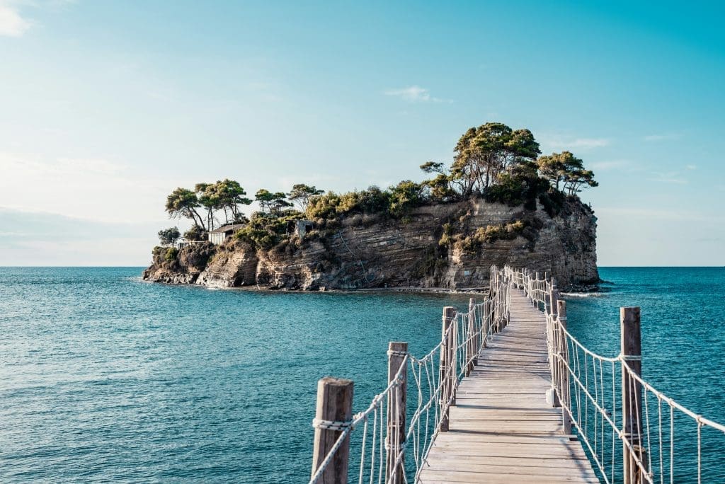 Photo by Julian Timmerman on Unsplash A rocky island in the ocean with a wooden walkway leading to it
