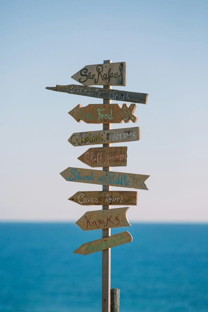 Photo by Marten Bjork on Unsplash Brown wooden signpost with multiple blank arrows against a pale sky and soft background.