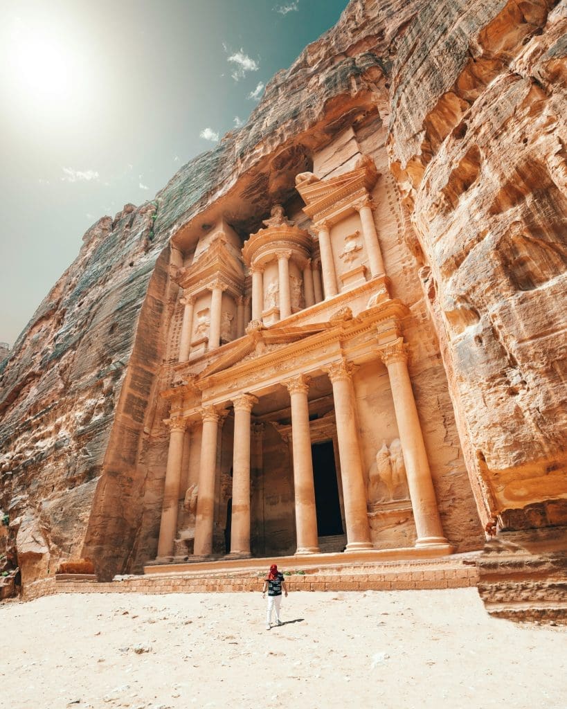 Photo by Spencer Davis on Unsplash man standing near ancient sandstone building in Petra Jordan desert